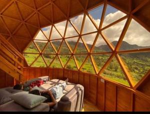 una camera con due persone sdraiate sui letti in una grande finestra di Colombia Mountain Tours Glamping and Cabanas a Choachí