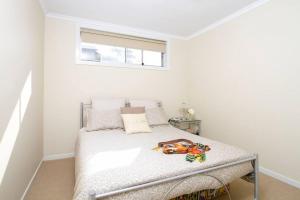 a white bedroom with a bed in a room at Ships Ahoy in Kiama