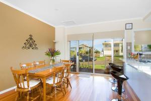 a dining room with a wooden table and chairs at Ships Ahoy in Kiama