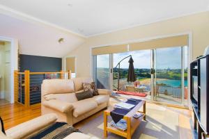 a living room with a couch and a tv at Ships Ahoy in Kiama