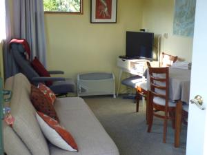 a living room with a couch and a table and a desk at Ligita's Homestay in Havelock