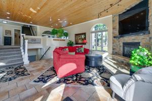 a living room with a red couch and a fireplace at Large Home with Indoor Basketball Court and Game Room! in Wisconsin Dells