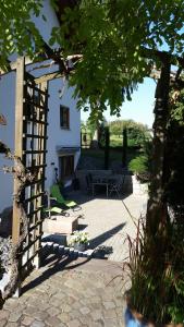einen Garten mit einem weißen Gebäude und einer Bank in der Unterkunft Ferienwohnung Hotte´s Hütte in Ettenheim