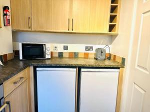 a kitchen with a counter top with a microwave at The Esplanade Lodge-Free Parking in Strood