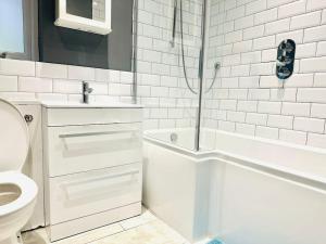a white bathroom with a shower and a toilet at The Esplanade Lodge-Free Parking in Strood +16 photos
