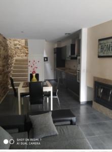 a living room with a dining table and a kitchen at A MIÑA CASIÑA in Ourense