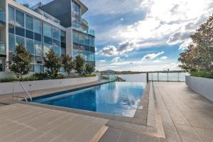 a swimming pool on the side of a building at Lakeside 1-Bed with Courtyard Pool Gym & Parking in Kingston 