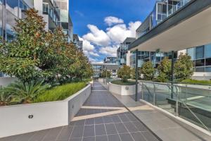a walkway in the middle of a building with plants at Lakeside 1-Bed with Courtyard Pool Gym & Parking in Kingston 
