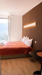 Schlafzimmer mit einem Bett, einem Fenster und einem Tisch in der Unterkunft Lake Star in Brissago