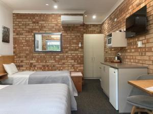 um quarto de hotel com duas camas e uma cozinha em Edge Of The Forest Motel em Margaret River Town