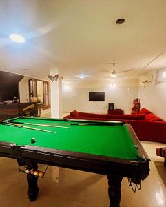 a pool table in a living room with a couch at Own stay Chhaterpur in New Delhi