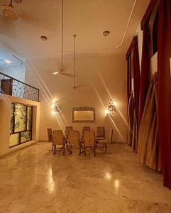 een kamer met stoelen, een tafel en verlichting bij Own stay Chhaterpur in New Delhi