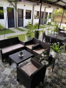 a patio with couches and tables and potted plants at JSS PENSION HOUSE 