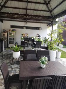 a patio with tables and chairs and plants in a restaurant at JSS PENSION HOUSE 
