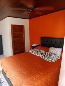 a bed in a room with an orange wall at Cabanas Zamoray 