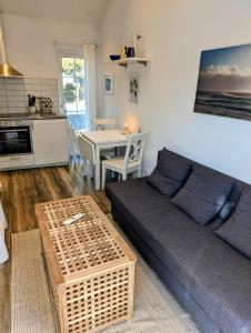 ein Wohnzimmer mit einem Sofa und einem Tisch in der Unterkunft Mini-villa 200 m from Kämpinge beach in Höllviken