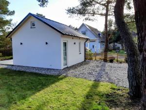 ein weißes Haus mit einem Baum davor in der Unterkunft Mini-villa 200 m from Kämpinge beach in Höllviken