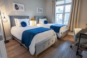 Dos camas en una habitación de hotel con ventana. en Modern Brand New 3BR 2B Apt in Heart of Athens, en Athens