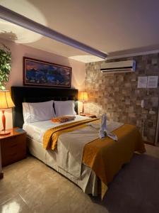 a bedroom with a large bed and a fan at HOTEL MUEVETE POR VARGAS in Catia La Mar