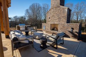 a patio with chairs and a brick fireplace at Modern Brand New 3BR 2B Apt in Heart of Athens in Athens