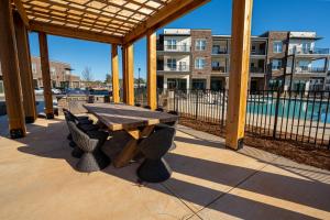 a wooden table and chairs on a patio with a building at Modern Brand New 3BR 2B Apt in Heart of Athens in Athens