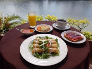 una mesa con platos de comida y una taza de zumo de naranja en Hotel Fragata en San Juan Bautista Tuxtepec