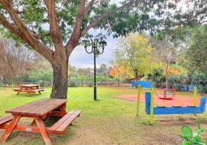 un parque con una mesa de picnic y un árbol en Spacious and Peaceful 2BD with a Garden & Parking en Gan H̱ayyim