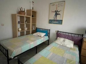 a room with two beds and a book shelf at Apartamento Guadalquivir - Parking Privado Opt in Seville