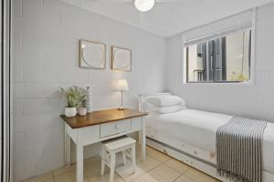 a bedroom with a bed and a desk and a window at Inner City apartment living in quiet location in Brisbane