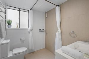 a bathroom with a shower and a toilet and a sink at Inner City apartment living in quiet location in Brisbane