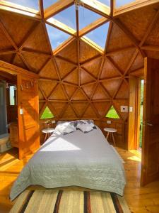 1 dormitorio con 1 cama grande en una habitación de madera en Colombia Mountain Tours Glamping and Cabanas, en Choachí