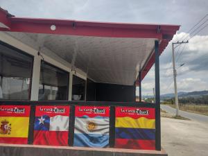 een tankstation met vlaggen aan de zijkant bij Hotel la cava del chef in Paipa