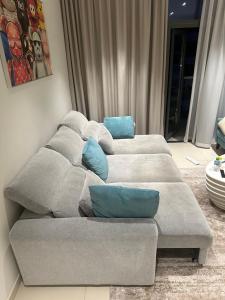 kanapę z niebieskimi poduszkami w salonie w obiekcie Beachfront Haven w Dubaju