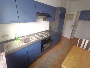 a kitchen with blue cabinets and a sink and a stove at 2 Room Apartment 15min to Fair in Hannover