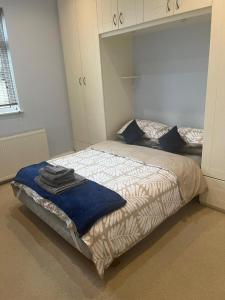 a bedroom with a bed with a blue blanket on it at Remarkable 1-Bed Apartment in North London N8 in London