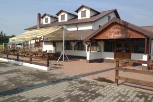 - un bâtiment avec un restaurant doté de bancs en face dans l'établissement Motel Valentina, à Ion Roată