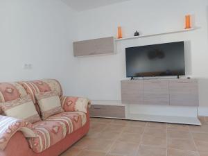 sala de estar con sofá y TV de pantalla plana en Casa Rural la Ruta del Vino Zarcilla de Ramos, en Lorca