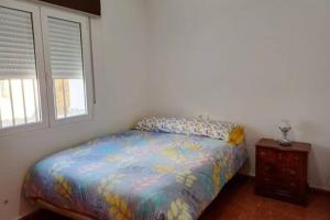 1 dormitorio con 1 cama, mesita de noche y 2 ventanas en Casa Rural la Ruta del Vino Zarcilla de Ramos, en Lorca