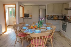 a kitchen and dining room with a table and chairs at Arthurs Cottage - rural hideaways in Norfolk in Edingthorpe