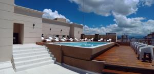 a rooftop patio with a pool on a building at Hotel Alvarado Suites in Salta