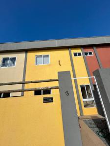 um edifício com uma porta amarela ao lado dele em Agapanto Praia em Marechal Deodoro