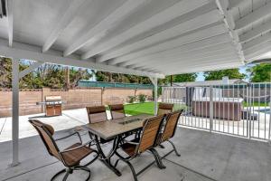 a patio with a table and chairs and a fence at New cheerful villa, Pool, Spa, Mini Golf, Game room, Fire pit next to Disneyland in Anaheim