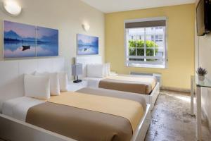 a hotel room with two beds and a window at Ocean Five Hotel in Miami Beach