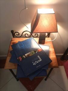 a wooden table with a lamp and a box on it at Maison du Fleurs in Taroudant