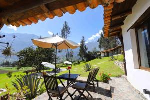 a table and chairs with an umbrella on a patio at Santa Cruz Eco Lodge in Huata