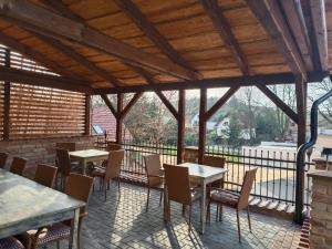 a patio with tables and chairs and a large window at Penzion Starovice in Starovice