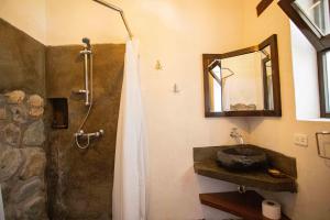 a bathroom with a sink and a shower with a mirror at Santa Cruz Eco Lodge in Huata