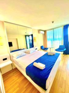 a bedroom with a large bed with a blue blanket at ORBI CITY batumi in Batumi