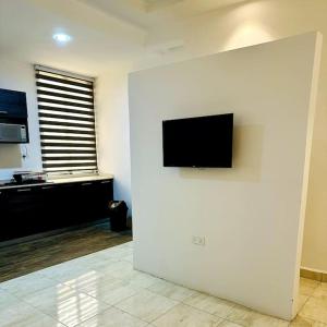 uma sala de estar com uma televisão de ecrã plano na parede em Spacious One Bedroom Apartment em Acra