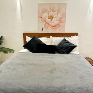 uma cama com almofadas pretas e brancas e um quadro em Spacious One Bedroom Apartment em Acra